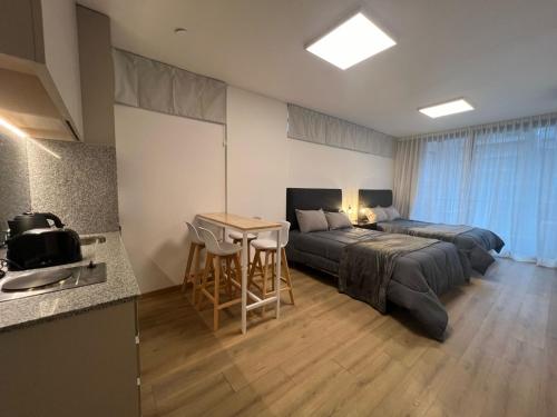 1 Schlafzimmer mit 2 Betten, einem Tisch und einer Küche in der Unterkunft Monroe Suites in Buenos Aires