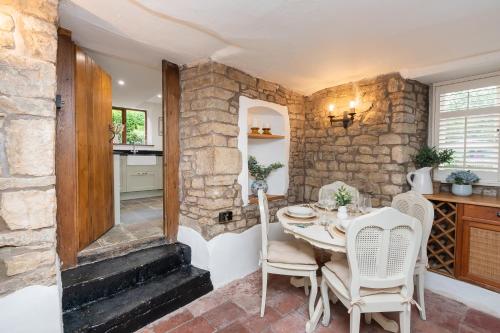 a dining room with a table and chairs at Cosy cottage on outskirts of Bath in Saltford