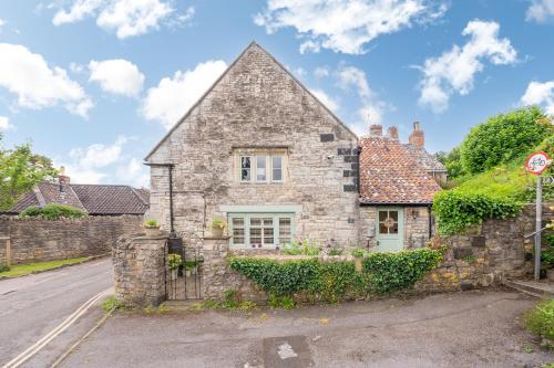 an old stone house on the side of a street at Cosy cottage on outskirts of Bath in Saltford