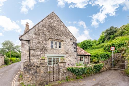 an old stone house on the side of a road at Cosy cottage on outskirts of Bath in Saltford