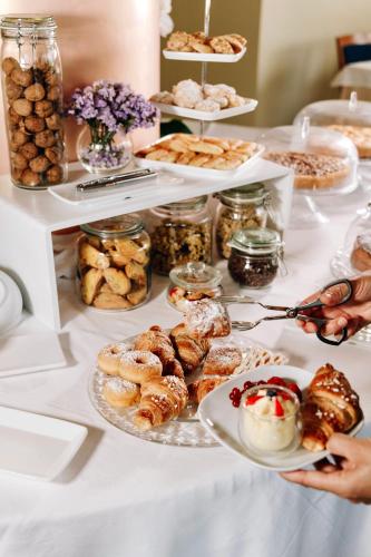a table topped with plates of pastries and desserts at Hotel Le Grotte in Genga
