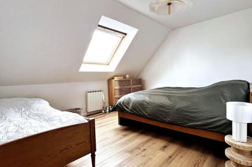 a attic bedroom with a bed and a window at L'Aparté à 5min de la plage de Hardelot in Neufchâtel-Hardelot