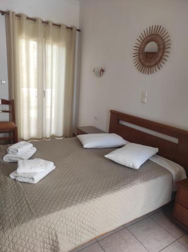 a bedroom with a bed with two pillows and a mirror at Vythos in Adamas