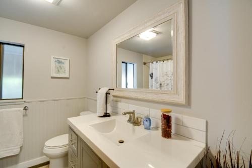 uma casa de banho branca com um lavatório e um espelho em Relaxing Poulsbo Duplex with Liberty Bay Views! em Poulsbo
