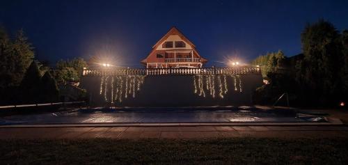 a house with christmas lights on a fence at night at Willa Wuja Sama in Zawóz