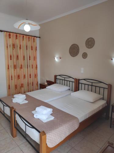 two beds in a hotel room with towels on them at Vythos in Adamas