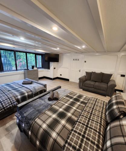 a living room with two beds and a couch at Rainsough Cottage Guest House - Shared Bathroom - Free Parking & WiFi in Manchester