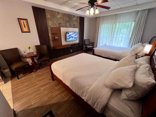 pokój hotelowy z 2 łóżkami i telewizorem z płaskim ekranem w obiekcie Hotel Valle del Rio w mieście Boquete