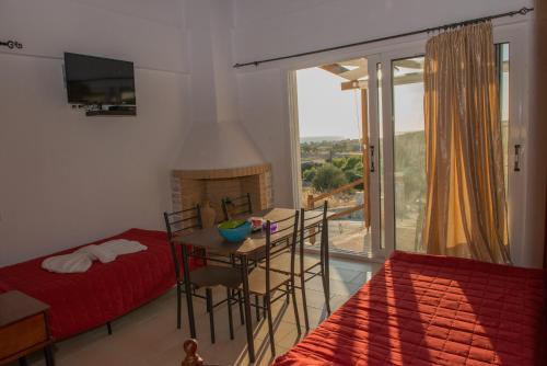 1 dormitorio con cama, mesa y ventana en Villa Oniro Kreta, en Kalamaki