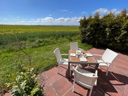a table with four chairs and a field of flowers at Apartment Ostseebrise im Ferienpark in Sagard