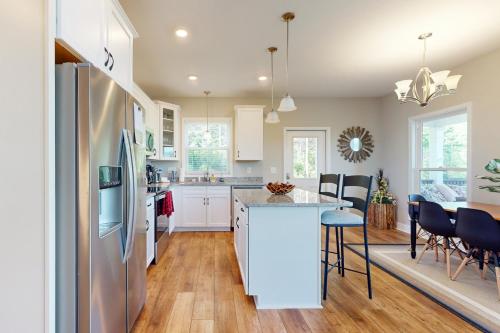 a kitchen and dining room with white cabinets and a kitchen island at Hidden Escape with a View in Mill Spring