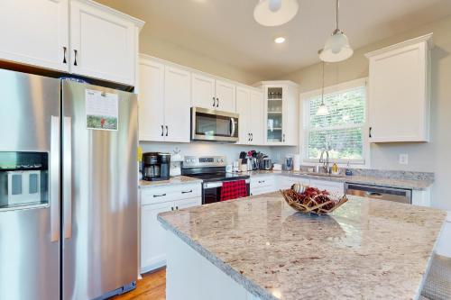 a kitchen with white cabinets and a bowl of fruit on a counter at Hidden Escape with a View in Mill Spring