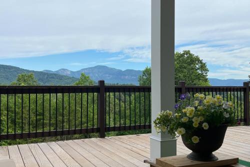 a vase of flowers on a deck with a view at Hidden Escape with a View in Mill Spring
