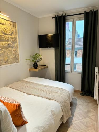 a bedroom with two beds and a window at Hotel Paris Amore in Paris