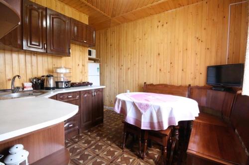 una cocina con una mesa con un mantel rosa. en Goryanka Hotel, en Mykulychyn