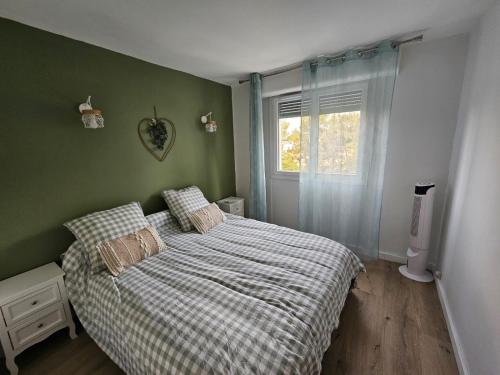 - une chambre dotée d'un lit avec une couverture tressée et une fenêtre dans l'établissement Appartement T3BIS - 74M2, à Marseille