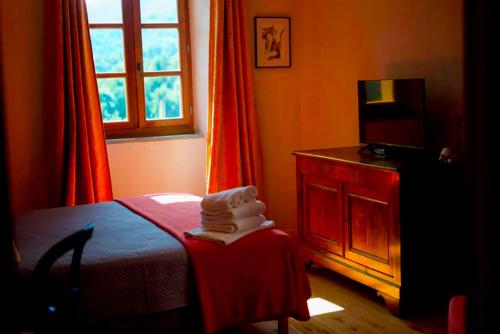 a bedroom with a bed and a dresser and a window at Casa Surgente in Carcheto