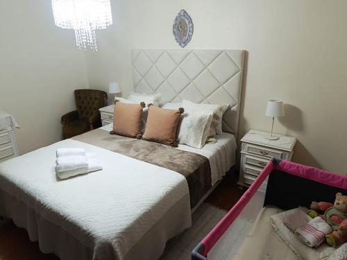 a bedroom with a large bed and a chandelier at Caroça House in Nazaré
