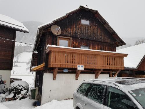 a house with a balcony on top of it in the snow at Die Alte Scheune by Globalimmoservice in Bad Kleinkirchheim