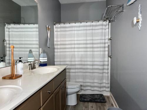 a bathroom with a shower curtain and a toilet at Murrels Inlet House Private Heated Saltwater Pool in Myrtle Beach