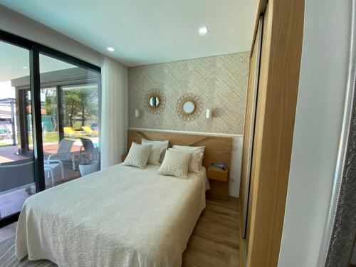 um quarto com uma cama e uma grande janela em Casa tapada da cheda 1 em Fafe