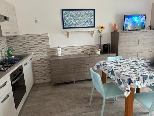 una cocina con mesa, sillas azules, mesa y mesa andizza en Happy Marina en Vasto