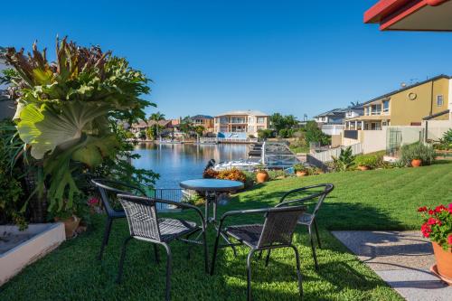a patio with chairs and a table next to the water at Waterfront BNB in Gold Coast