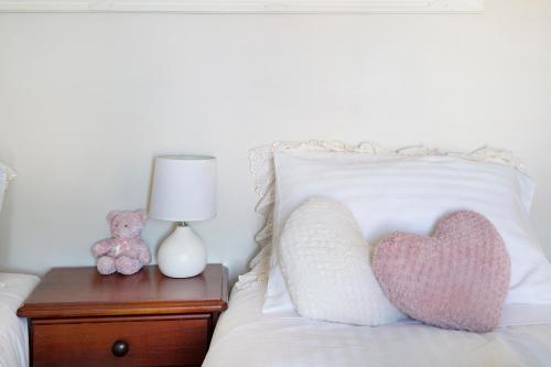 a heart pillow on a bed next to a nightstand at Waterfront BNB in Gold Coast