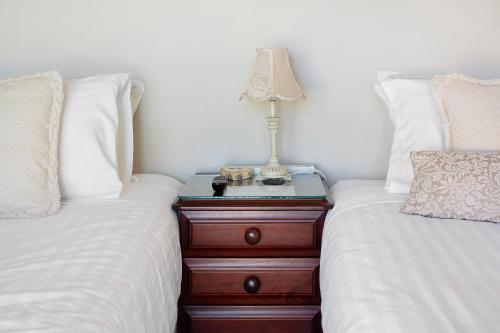 a nightstand between two beds with a lamp on it at Waterfront BNB in Gold Coast