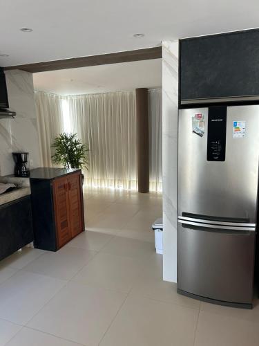 a kitchen with a stainless steel refrigerator in a room at Apartamento Chique frente ao mar in Flecheiras