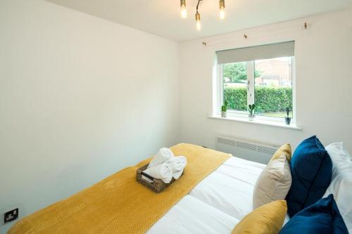 a bedroom with a bed with two towels on it at Cozy Retreat Near Heathrow Airport in Feltham