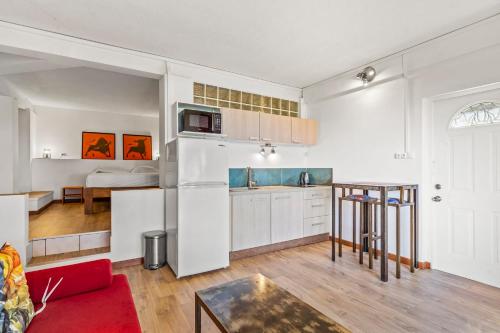 a kitchen and living room with a couch and a table at Luxurious 3BR Villa with Infinity Pool in Temae