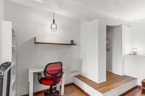 a red chair sits in a room with a staircase at Luxurious 3BR Villa with Infinity Pool in Temae