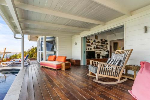 a porch with rocking chairs and a fireplace at Luxurious 3BR Villa with Infinity Pool in Temae
