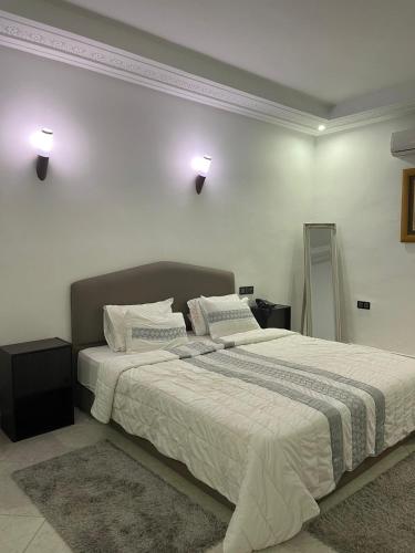 a bedroom with a large bed with white sheets at Palais Benfatah in Marrakesh