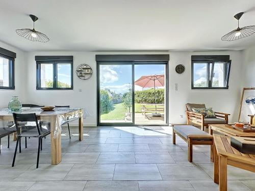 - un salon avec une table et une vue sur la cour dans l'établissement Ty Ehanou ravissante maison de vacances, à Landunvez