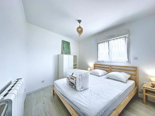 une chambre avec un lit avec des draps blancs et une fenêtre dans l'établissement Ty Ehanou ravissante maison de vacances, à Landunvez