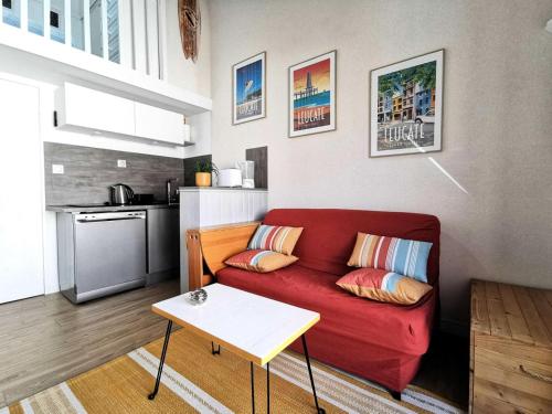 un salon avec un canapé rouge et une cuisine dans l'établissement Résidence Hawai 1 - VILLA T1 CAB MEZZ 5 couchages PORT LEUCATE MAE-6964, à Leucate