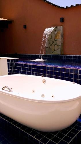 a bath tub in a bathroom with a fountain at Refugio da praia in Paraty