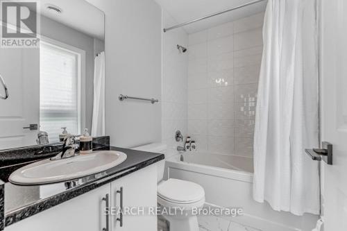 a bathroom with a sink and a tub and a toilet at Cozy 3 story Townhouse! in Niagara Falls