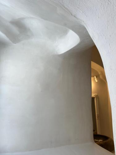 a room with a white wall and an archway at Cave Noelia in Fira