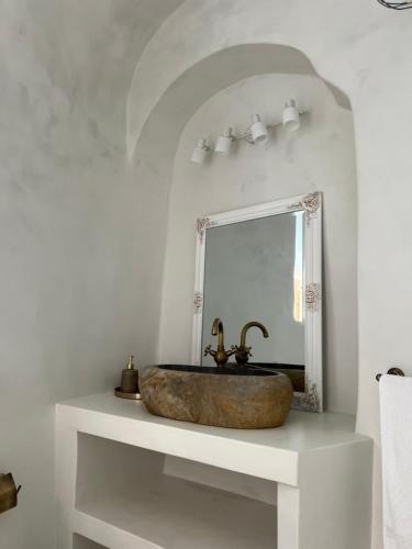 a bathroom with a stone sink and a mirror at Cave Noelia in Fira
