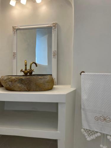 a bathroom with a stone sink with a mirror at Cave Noelia in Fira