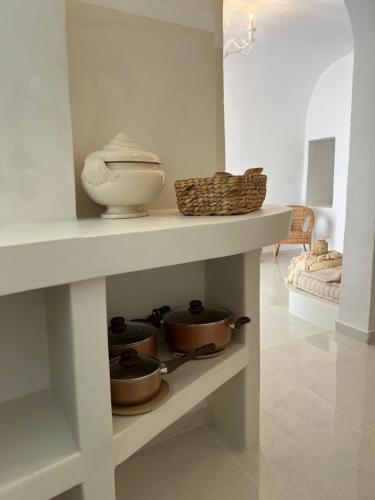 a white shelf with pots and pans on it at Cave Noelia in Fira