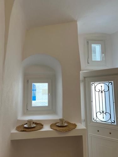 a white room with a window and two baskets at Cave Noelia in Fira