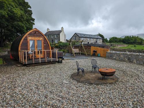 ein großer Garten mit einem Holzhaus und Stühlen in der Unterkunft The Pod Fabulous glamping pod near Snowdonia. in Caernarfon