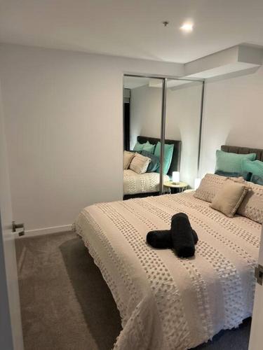 a bedroom with a bed with a black hat on it at 112 at Plush Midnight in Canberra