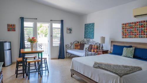 a bedroom with a bed and a table and chairs at Wild Flowers Rooms in Boqueron