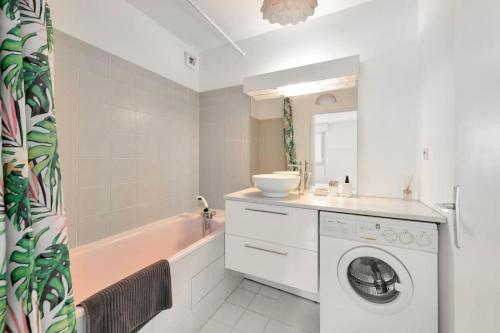 une salle de bain avec un lave-linge et une baignoire dans l'établissement Bel appartement en bord de mer à Juan Les Pins, à Juan-les-Pins