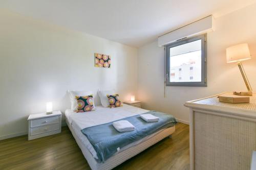 une chambre avec un grand lit avec une fenêtre dans l'établissement Bel appartement en bord de mer à Juan Les Pins, à Juan-les-Pins
